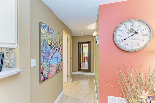 136 Crescent Dr, Anna Maria, FL 34216 - hallway featuring baseboards, visible vents, and light wood-style flooring