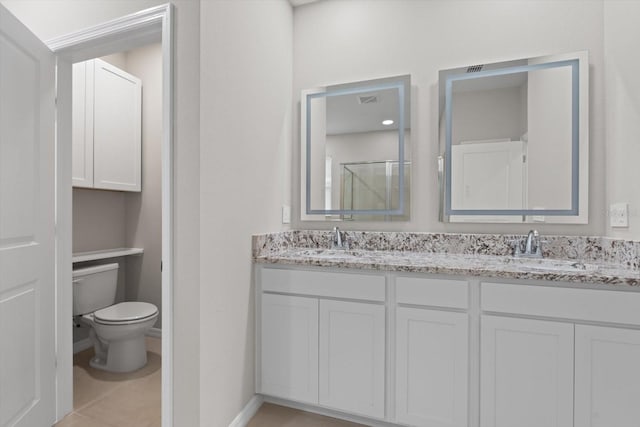 bathroom featuring vanity, toilet, and tile patterned flooring