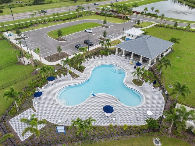 view of pool featuring a water view and a patio