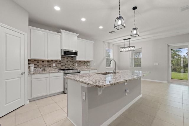 kitchen featuring white cabinets, appliances with stainless steel finishes, an island with sink, and sink