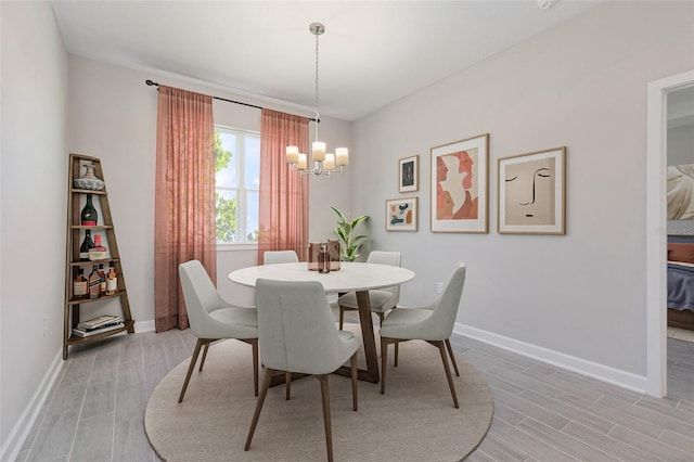 dining space with light hardwood / wood-style flooring and a chandelier