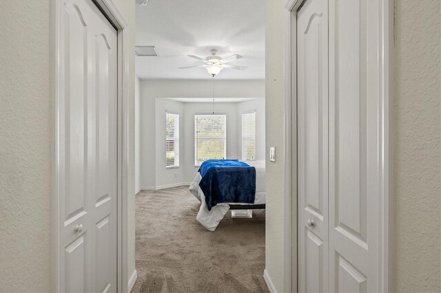 hall featuring light colored carpet