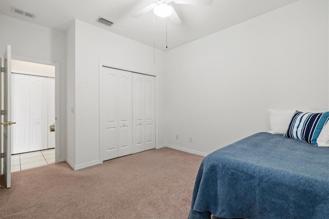 bedroom with a closet, ceiling fan, and light carpet