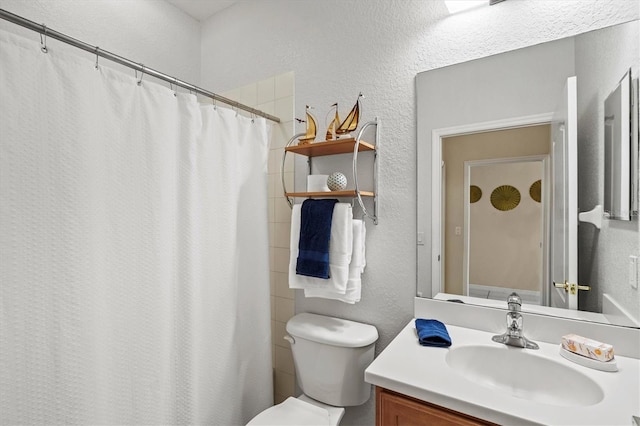 bathroom featuring a shower with shower curtain, vanity, and toilet