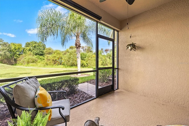 sunroom featuring ceiling fan and plenty of natural light