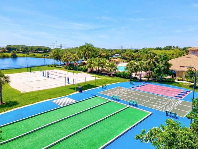 view of home's community with volleyball court, a yard, and a water view