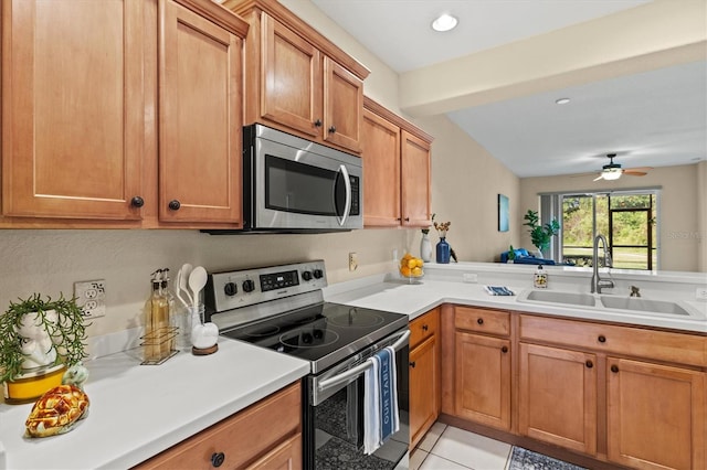 kitchen featuring sink, ceiling fan, light tile patterned floors, kitchen peninsula, and appliances with stainless steel finishes