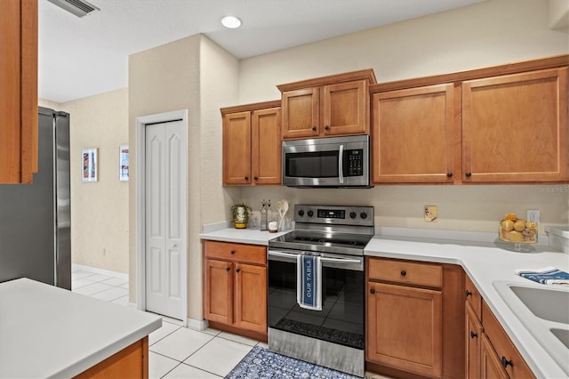 kitchen featuring sink, light tile patterned floors, and appliances with stainless steel finishes