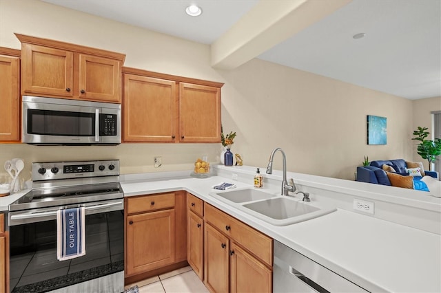 kitchen featuring kitchen peninsula, stainless steel appliances, light tile patterned floors, and sink