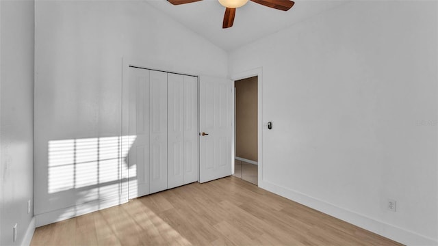 unfurnished bedroom with a closet, ceiling fan, vaulted ceiling, and light hardwood / wood-style floors