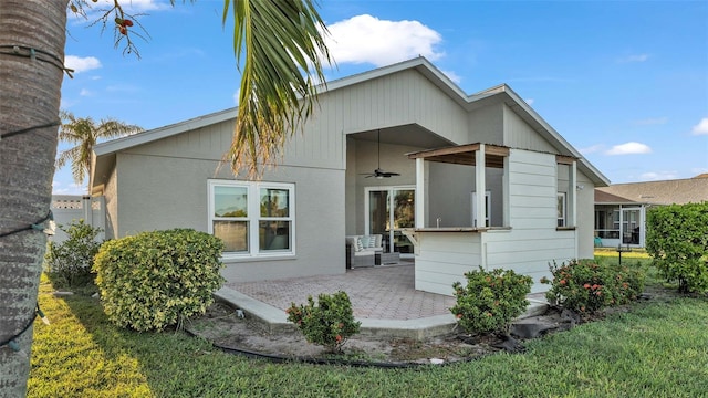 back of property with a lawn, ceiling fan, and a patio