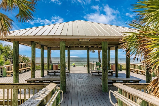 exterior space with a gazebo, a deck with water view, and a view of the beach