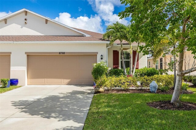 8798 Tuscany Isles Dr, Punta Gorda, FL 33950 - ranch-style home featuring stucco siding, driveway, an attached garage, and a front yard
