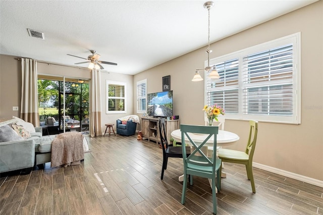 dining area featuring a textured ceiling, ceiling fan, and hardwood / wood-style floors