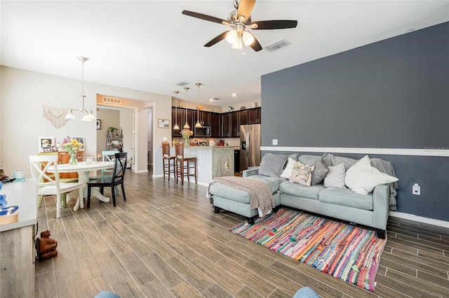 living room with ceiling fan and dark hardwood / wood-style floors