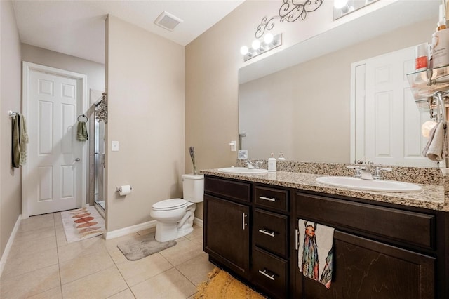 bathroom with tile patterned floors, toilet, a shower with door, and vanity