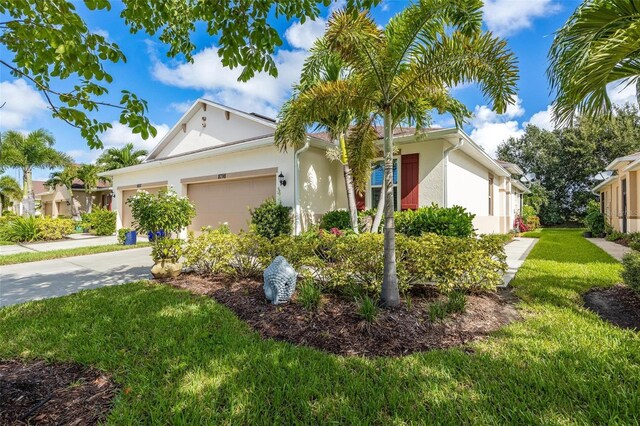 8798 Tuscany Isles Dr, Punta Gorda, FL 33950 - ranch-style house featuring stucco siding, driveway, a garage, and a front lawn