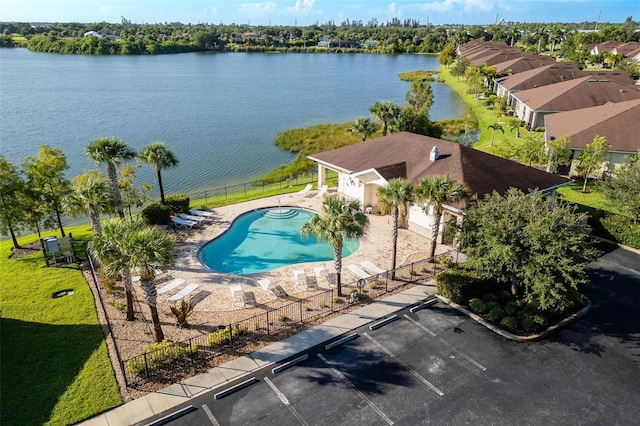 view of pool featuring a water view, a yard, and a patio