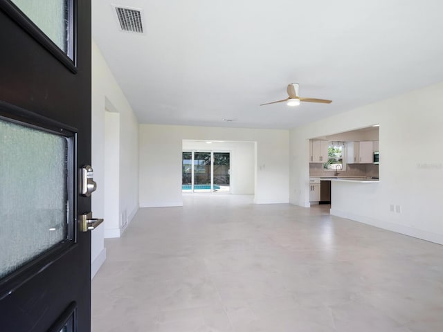 unfurnished living room featuring a healthy amount of sunlight and ceiling fan