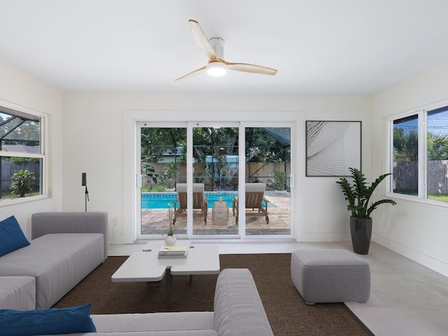 living room featuring concrete flooring and ceiling fan