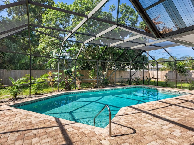 view of pool with glass enclosure and a patio area