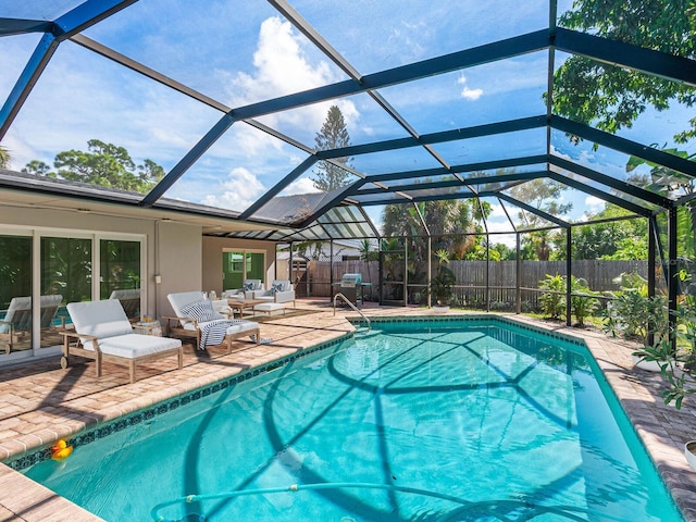 view of swimming pool featuring a patio area and glass enclosure