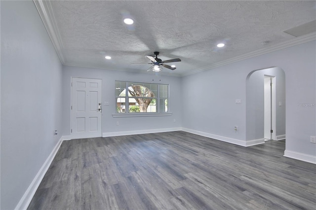 empty room with ceiling fan, dark hardwood / wood-style flooring, a textured ceiling, and ornamental molding