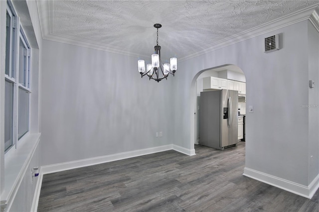 empty room featuring dark hardwood / wood-style floors, a textured ceiling, and ornamental molding