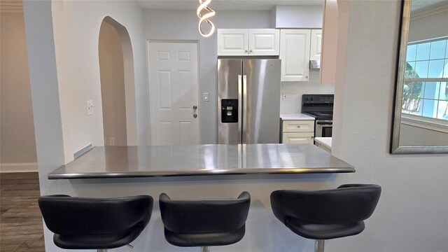 kitchen featuring dark hardwood / wood-style flooring, white cabinetry, black range oven, stainless steel fridge with ice dispenser, and tasteful backsplash