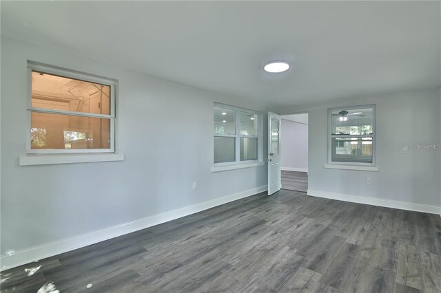 unfurnished room featuring a healthy amount of sunlight and dark hardwood / wood-style floors