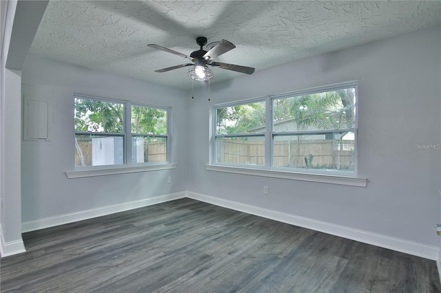 empty room featuring dark wood-type flooring, ceiling fan, and a textured ceiling