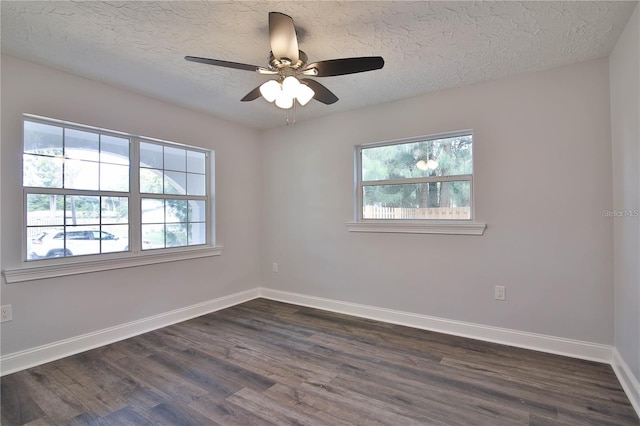 spare room featuring ceiling fan, plenty of natural light, and dark hardwood / wood-style floors