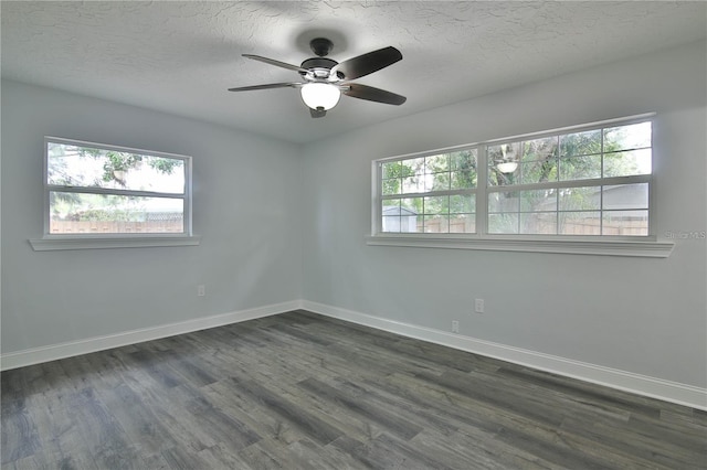 empty room featuring ceiling fan, dark hardwood / wood-style flooring, and a healthy amount of sunlight