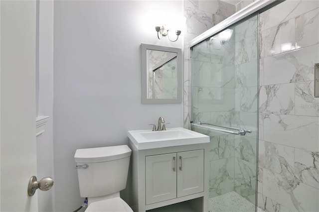 bathroom featuring a shower with door, vanity, and toilet