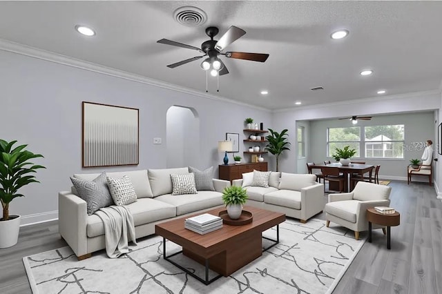 2912 Pinecrest Way, Sarasota, FL 34239 - living area featuring a ceiling fan, crown molding, arched walkways, light wood-style floors, and recessed lighting