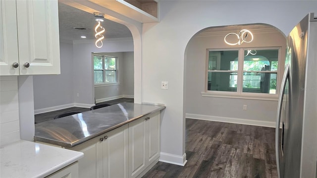 2912 Pinecrest Way, Sarasota, FL 34239 - kitchen with freestanding refrigerator, arched walkways, white cabinets, ornamental molding, and dark wood-style flooring