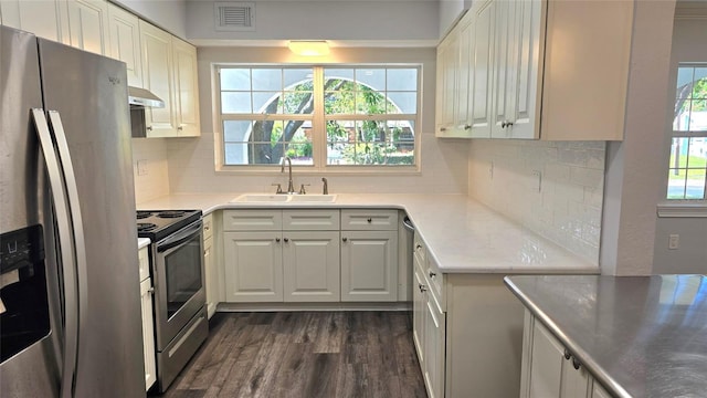 2912 Pinecrest Way, Sarasota, FL 34239 - kitchen with stainless steel appliances, dark wood finished floors, decorative backsplash, light countertops, and white cabinetry