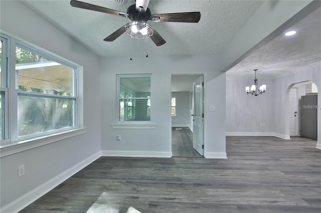 2912 Pinecrest Way, Sarasota, FL 34239 - empty room with a ceiling fan, a chandelier, arched walkways, a textured ceiling, and dark wood-style flooring