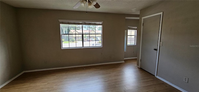 empty room featuring ceiling fan, a textured ceiling, and hardwood / wood-style floors