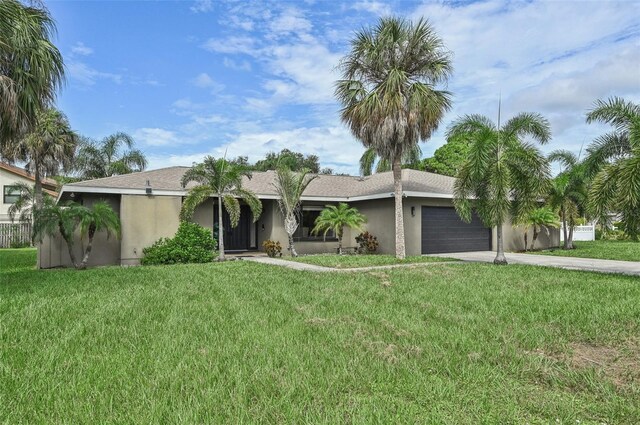 ranch-style home featuring a garage and a front lawn