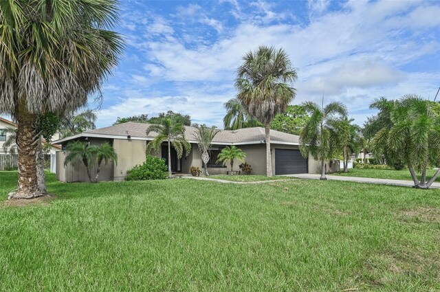 ranch-style home with a garage and a front lawn