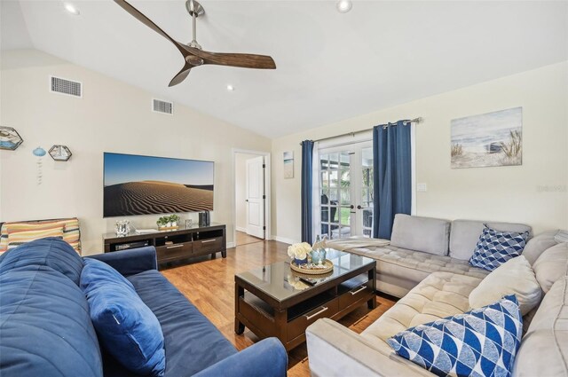 living room with hardwood / wood-style floors, ceiling fan, and vaulted ceiling