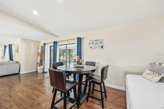 dining area with lofted ceiling and dark wood-type flooring