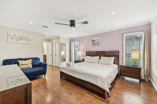 bedroom featuring ensuite bath, ornamental molding, wood-type flooring, and ceiling fan