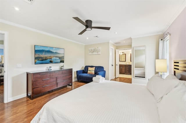 bedroom with visible vents, baseboards, wood finished floors, and ornamental molding