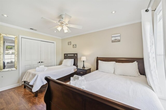 bedroom with ornamental molding, dark hardwood / wood-style flooring, ceiling fan, and a closet