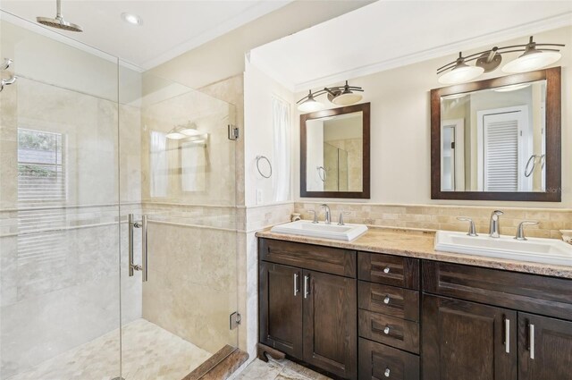 bathroom featuring a shower with door, vanity, backsplash, tile walls, and crown molding