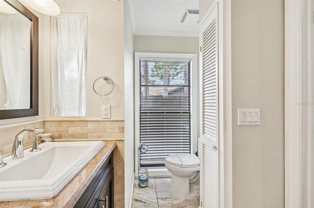 bathroom with crown molding, vanity, and toilet