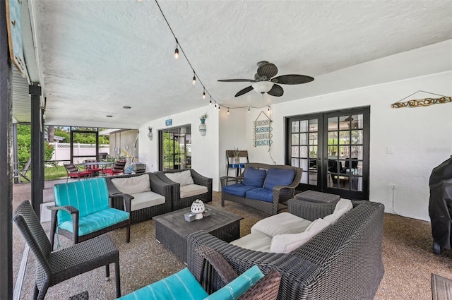 living area with a ceiling fan, french doors, speckled floor, and a textured ceiling