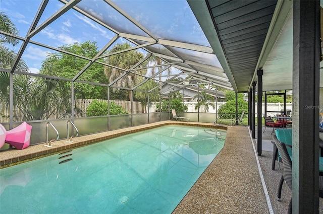 view of swimming pool featuring glass enclosure and a patio